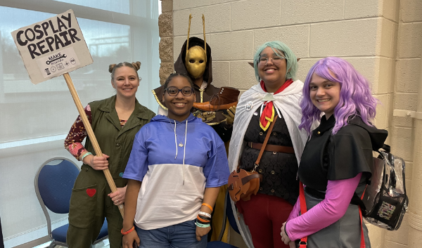 A group of people from the 2024 Big Lick Comic Con, including Georgina (left) holding our Cosplay Repair sign
