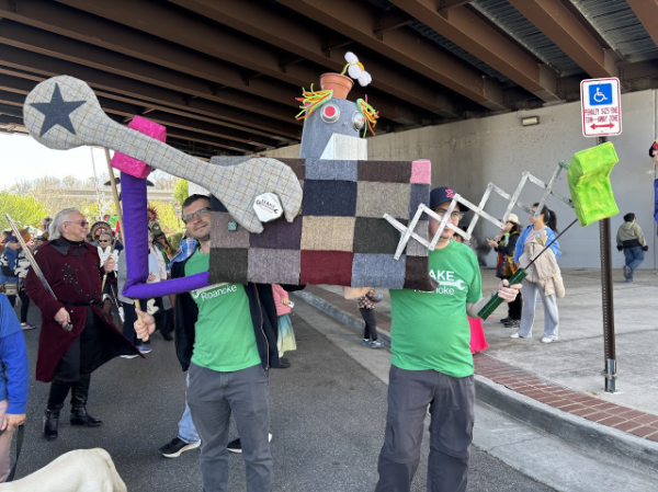 Hristo and Sam holding our 2024 Daisy Art Parade puppet, a Maker Robot!