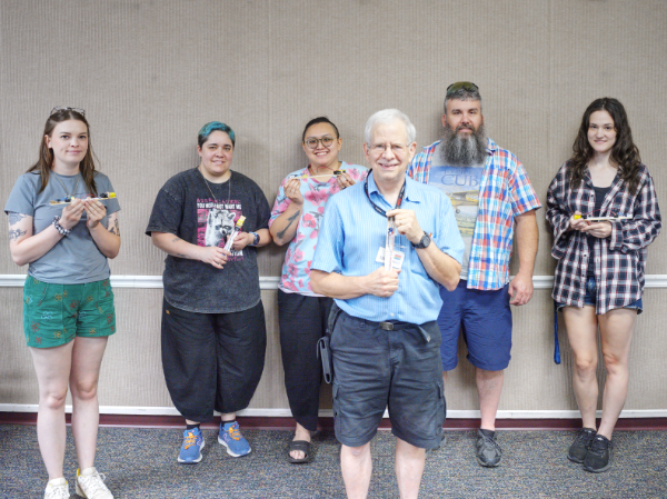 David in the foreground with 5 people standing in the background holding the breadboards used in their class